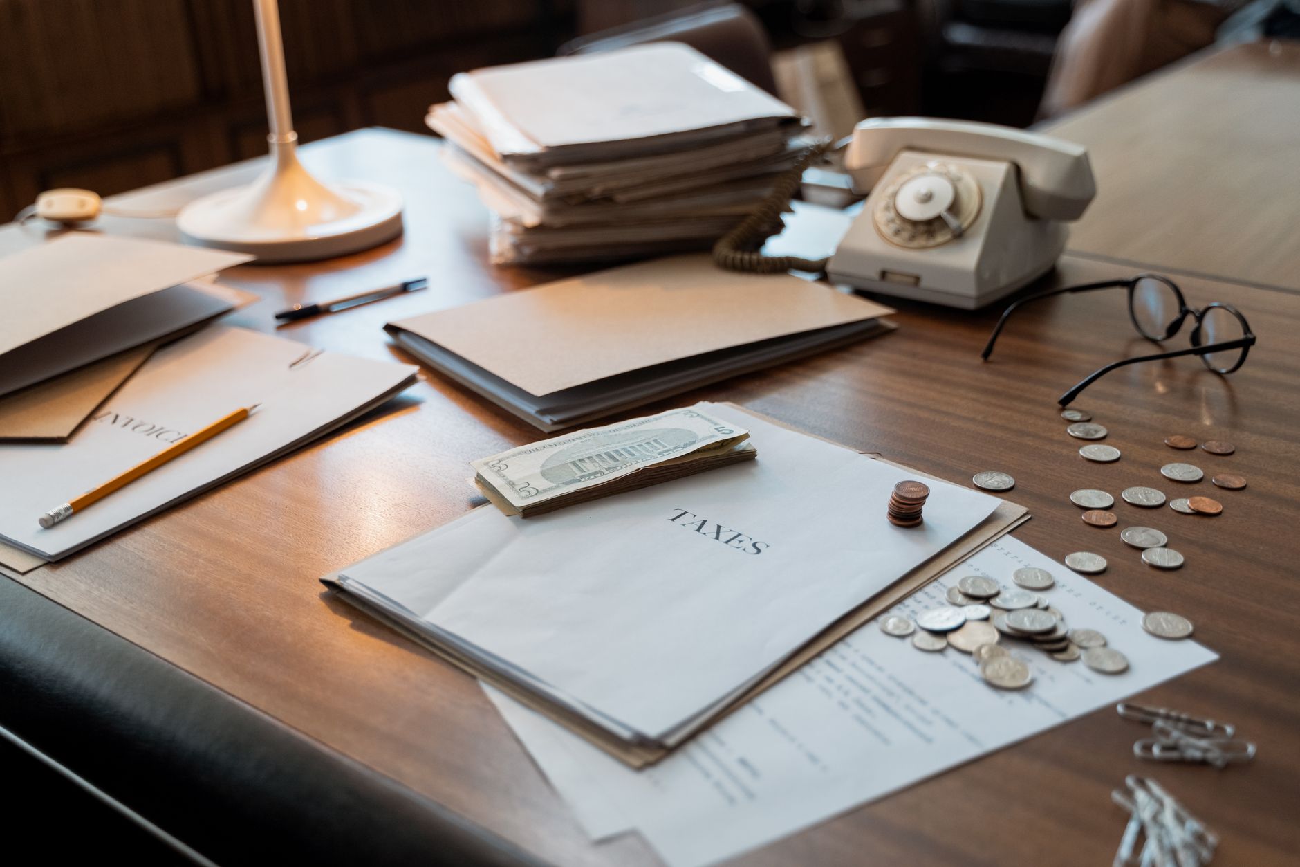 Mesa com documentos, celular e anotações para conferir uma cobrança em nome da ERFOLG
