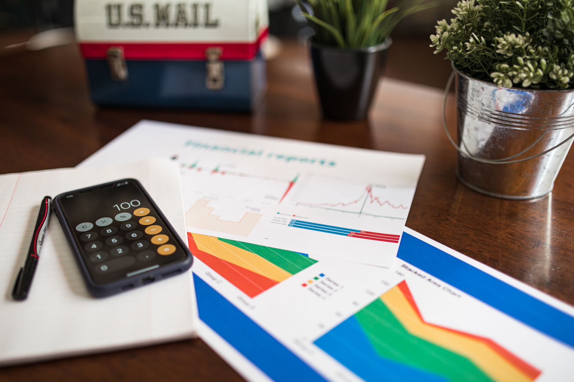 Celular com conversa aberta ao lado de documentos financeiros e caderno