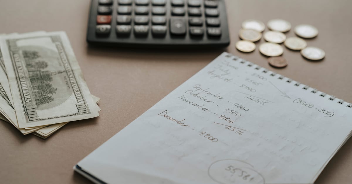 Caderno de orcamento, calculadora e dinheiro separados por prioridade